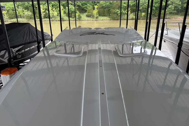 Slide: The Image of 2001 Baja 33 Outlaw boat docked under a canopy near a river. - 4