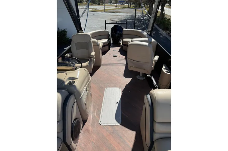 Slide: The Image of 2017 South Bay 523RS pontoon boat interior with beige seating and wood flooring. - 11