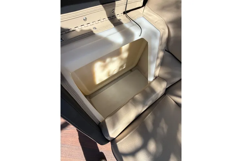 Slide: The Image of Open storage compartment in 2017 South Bay 523RS boat seat, beige upholstery. - 13