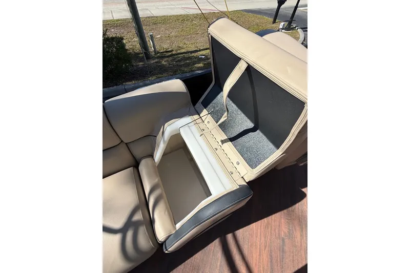 Slide: The Image of Open storage compartment in 2017 South Bay 523RS boat seat, beige upholstery. - 18