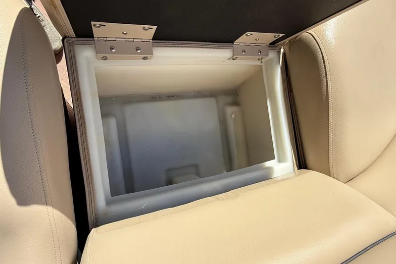 Slide: The Image of Open storage compartment in 2017 South Bay 523RS boat seat, showcasing beige upholstery. - 9