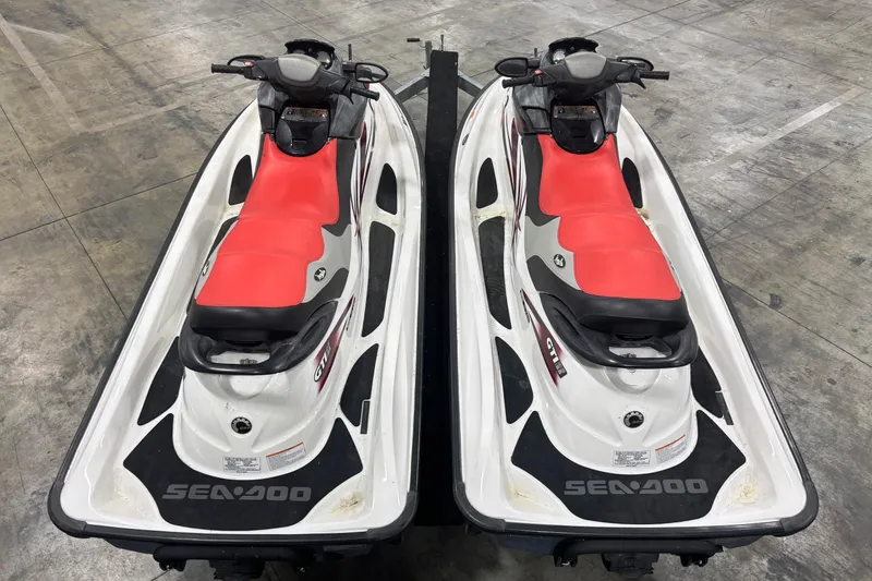 Slide: The Image of Two 2008 Seadoo GTI SE 155 jet skis with red seats on a concrete floor. - 10
