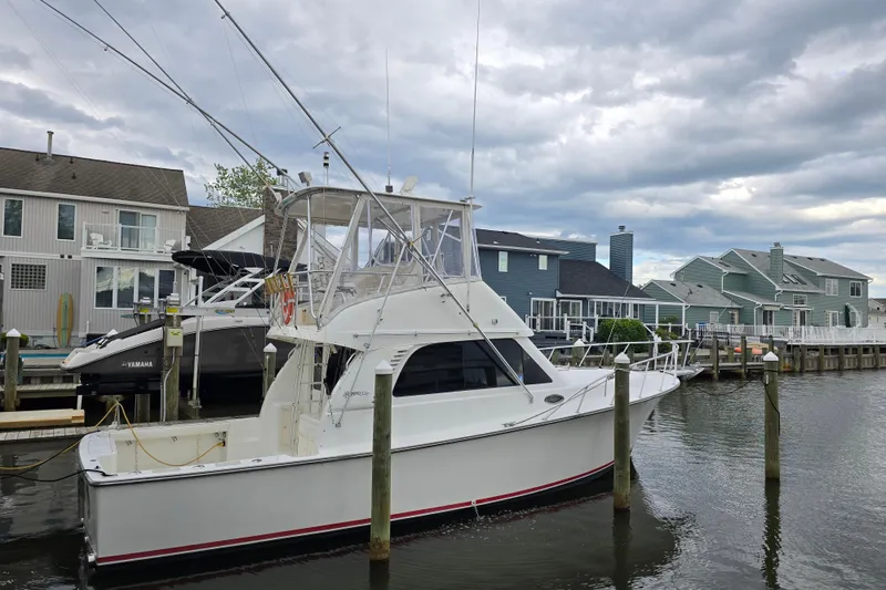 Slide: The Image of 2003 Henriques 35 Sportfisherman docked in a residential marina under cloudy skies. - 1