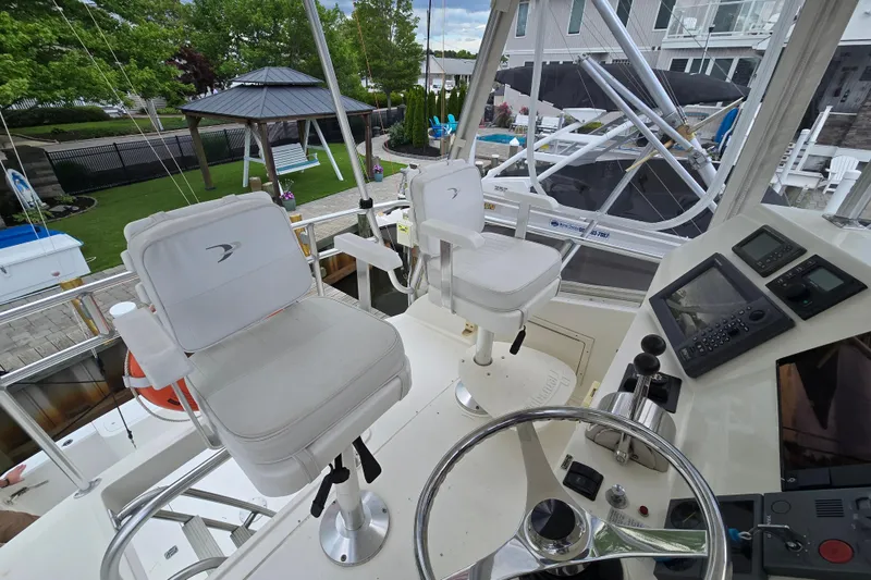 Slide: The Image of Helm of 2003 Henriques 35 Sportfisherman with white captain chairs and navigation equipment. - 11