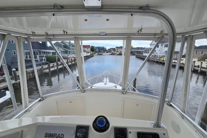 Slide: The Image of View from 2003 Henriques 35 Sportfisherman helm, overlooking a serene waterfront neighborhood. - 13