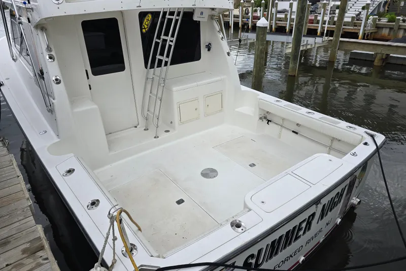 Slide: The Image of 2003 Henriques 35 Sportfisherman boat docked, featuring spacious deck and ladder access. - 15