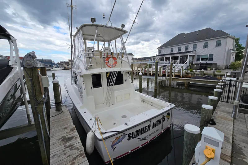 Slide: The Image of 2003 Henriques 35 Sportfisherman docked at marina, overcast sky, residential backdrop. - 2