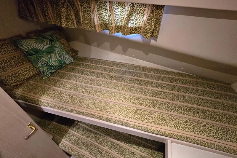 Slide: The Image of 2003 Henriques 35 Sportfisherman cabin with leopard print bedding and tropical pillows. - 20