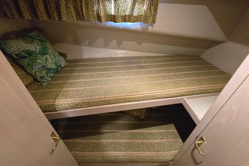 Slide: The Image of 2003 Henriques 35 Sportfisherman cabin with patterned bunk beds and tropical-themed pillows. - 21