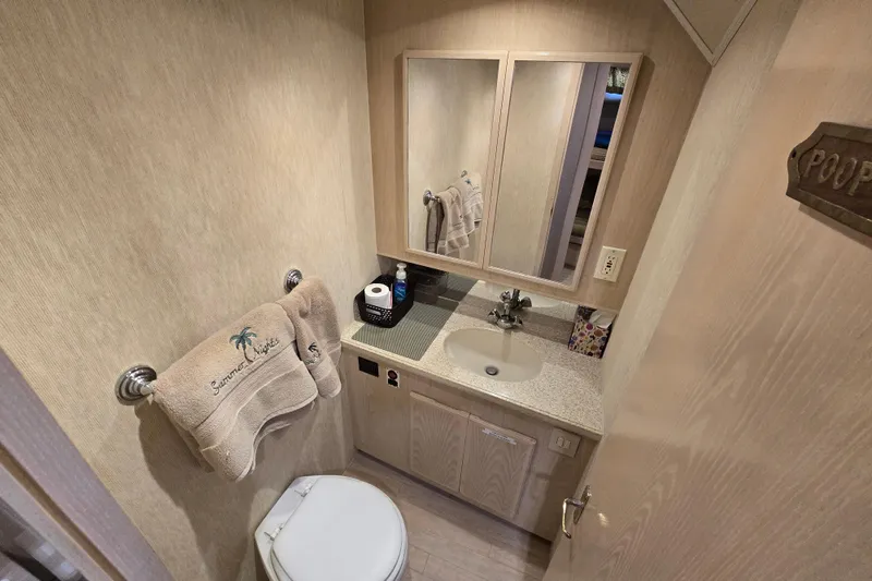Slide: The Image of Compact bathroom in a 2003 Henriques 35 Sportfisherman boat, featuring sink and toilet. - 23