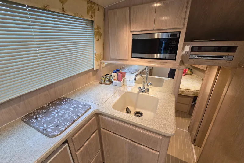 Slide: The Image of 2003 Henriques 35 Sportfisherman interior kitchen with sink, microwave, and storage cabinets. - 26