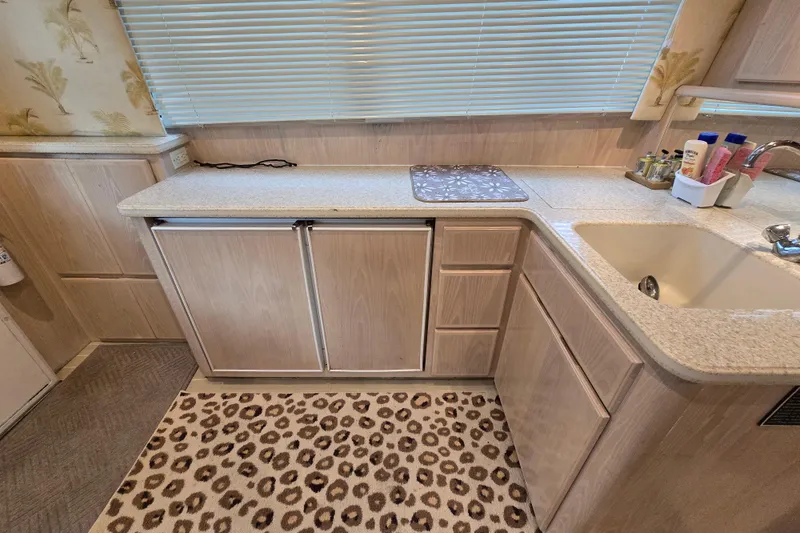 Slide: The Image of Interior of 2003 Henriques 35 Sportfisherman kitchen with cabinets, sink, and leopard print rug. - 27