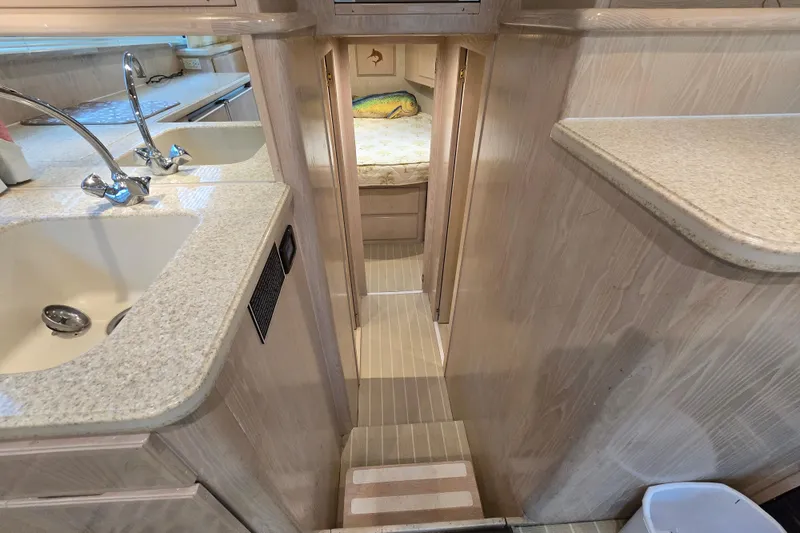 Slide: The Image of Interior of 2003 Henriques 35 Sportfisherman, featuring a compact kitchen and cozy sleeping area. - 29