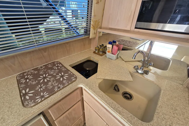 Slide: The Image of Compact kitchen area in a 2003 Henriques 35 Sportfisherman boat with sink and stove. - 32