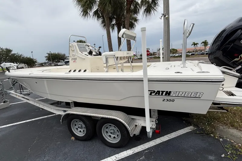 The Image of 2021 Pathfinder 2300 HPS boat on trailer, parked outdoors near palm trees. - 1