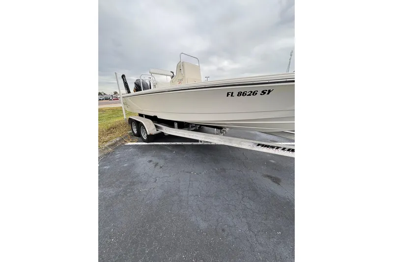 Slide: The Image of 2021 Pathfinder 2300 HPS boat on trailer, parked on asphalt. - 4