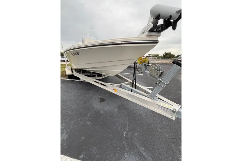 Slide: The Image of 2021 Pathfinder 2300 HPS boat on trailer, parked on asphalt under cloudy sky. - 5