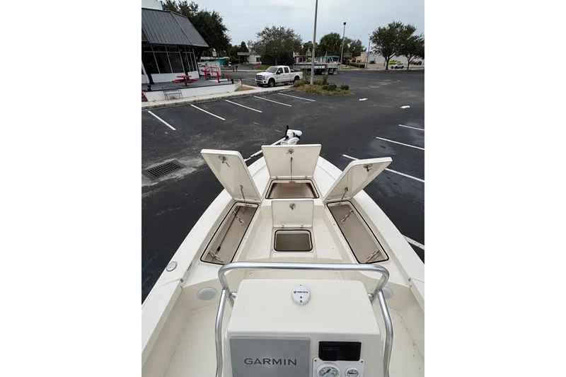Slide: The Image of 2021 Pathfinder 2300 HPS boat with open storage compartments in a parking lot. - 6