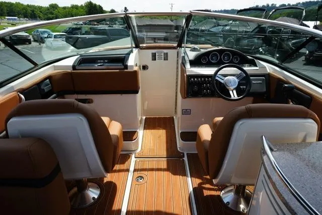 Slide: The Image of Interior view of 2014 Sea Ray 270 SLX boat with brown seating and wood flooring. - 11