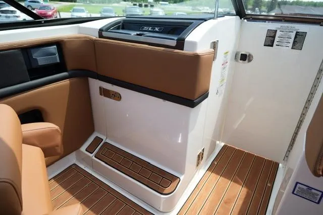 Slide: The Image of Interior of 2014 Sea Ray 270 SLX boat with brown leather seating and wood flooring. - 14
