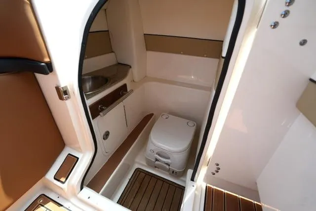 Slide: The Image of 2014 Sea Ray 270 SLX boat interior with compact bathroom and toilet. - 19