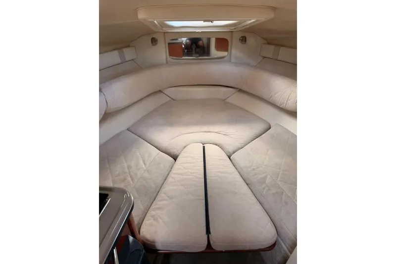 Slide: The Image of 2007 Sea Ray 240 Sundancer cabin interior with beige upholstery and compact design. - 14