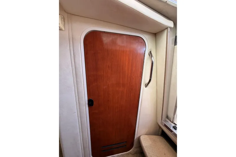Slide: The Image of Wooden cabin door inside 2007 Sea Ray 240 Sundancer boat, featuring a sleek handle. - 19