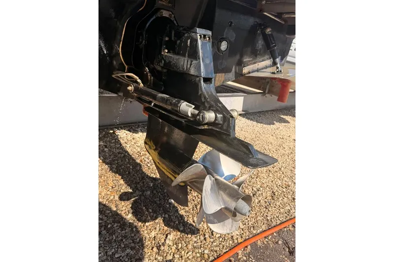 Slide: The Image of 2007 Sea Ray 240 Sundancer boat propeller and stern drive on gravel surface. - 4