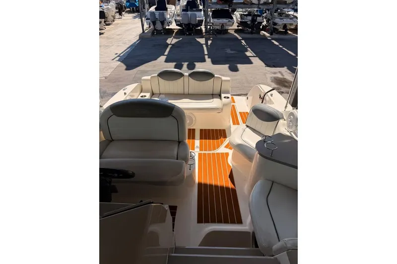 Slide: The Image of 2007 Sea Ray 240 Sundancer boat interior with seating and wood-style flooring. - 6