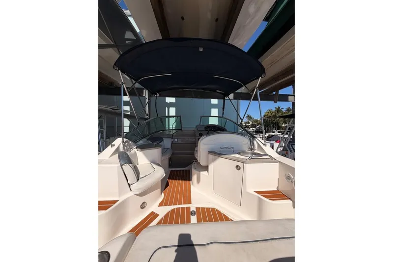 Slide: The Image of 2007 Sea Ray 240 Sundancer boat interior with seating and canopy, docked under shelter. - 8