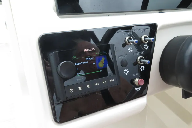 Slide: The Image of 2023 Sea Ray SPX 210 Outboard dashboard with Fusion audio system and control switches. - 11