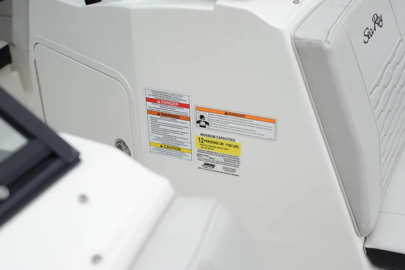 Slide: The Image of 2023 Sea Ray SPX 210 Outboard boat interior with safety and capacity labels. - 14