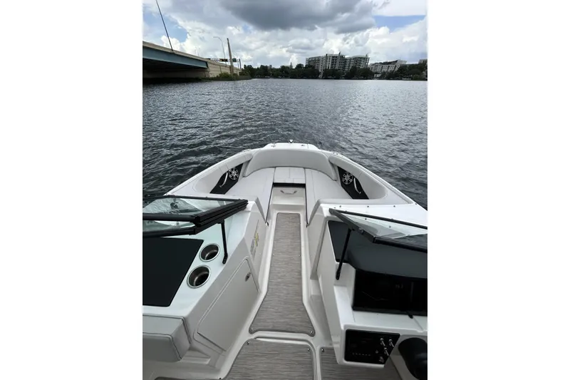 Slide: The Image of 2023 Sea Ray SPX 210 Outboard boat interior on a calm river under cloudy skies. - 5