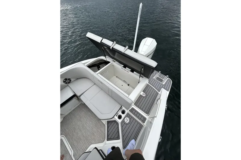 Slide: The Image of 2023 Sea Ray SPX 210 Outboard boat interior with open storage compartment on water. - 6