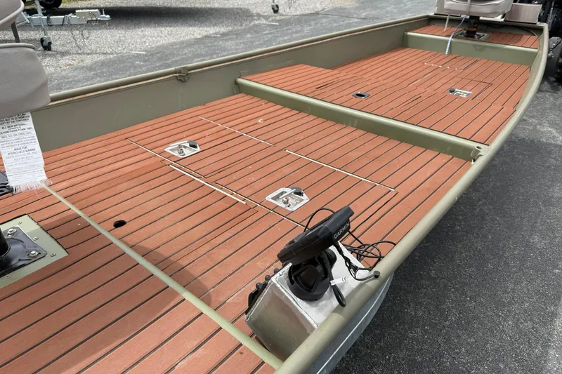 Slide: The Image of 2025 Tracker Grizzly 1542 boat with wood-patterned deck and mounted equipment. - 11