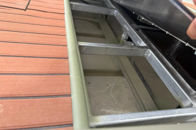 Slide: The Image of Interior view of a 2025 Tracker Grizzly 1542 boat, showcasing metal framework and storage compartment. - 12