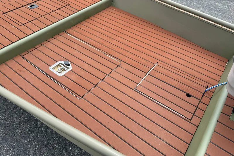 Slide: The Image of 2025 Tracker Grizzly 1542 boat deck with wood finish and storage compartments. - 7