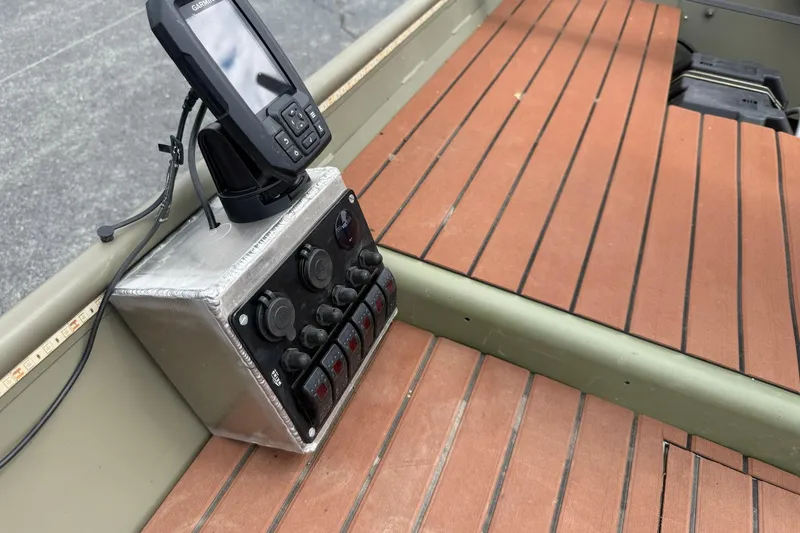 Slide: The Image of 2025 Tracker Grizzly 1542 boat dashboard with control panel and GPS device. - 9
