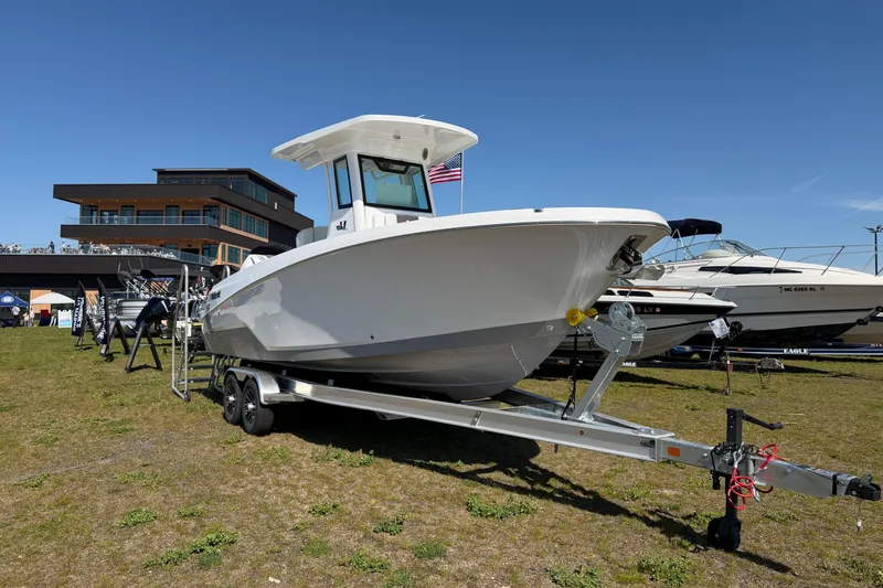 The Image of 2026 Wellcraft 243 Fisherman boat on trailer, displayed outdoors near modern building. - 0