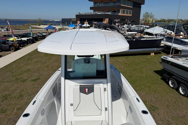 Slide: The Image of 2026 Wellcraft 243 Fisherman boat displayed outdoors at a marina event. - 13