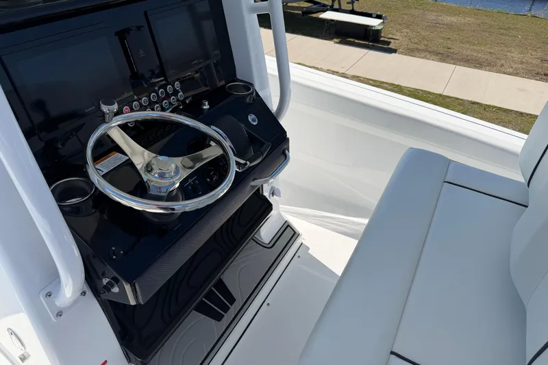 Slide: The Image of 2026 Wellcraft 243 Fisherman boat cockpit with steering wheel and control panel. - 7
