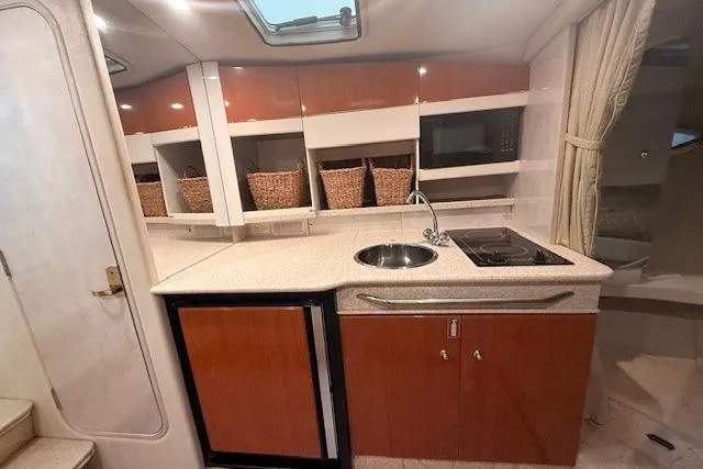Slide: The Image of 2003 Formula 31 Performance Cruiser interior kitchen with sink, stove, and storage baskets. - 17