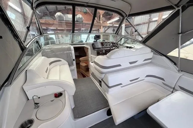 Slide: The Image of 2003 Formula 31 Performance Cruiser interior with white seating and helm in a covered dock. - 9