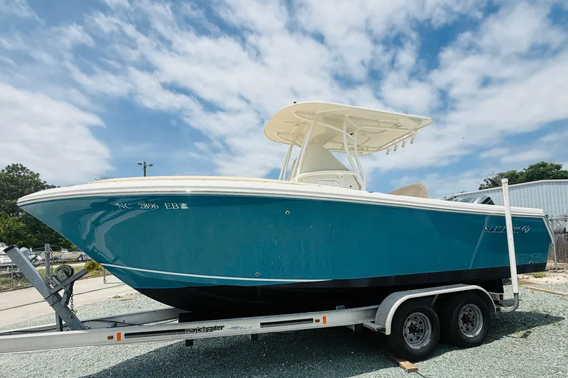 The Image of 2015 Sailfish 240 CC boat on trailer under a partly cloudy sky. - 1