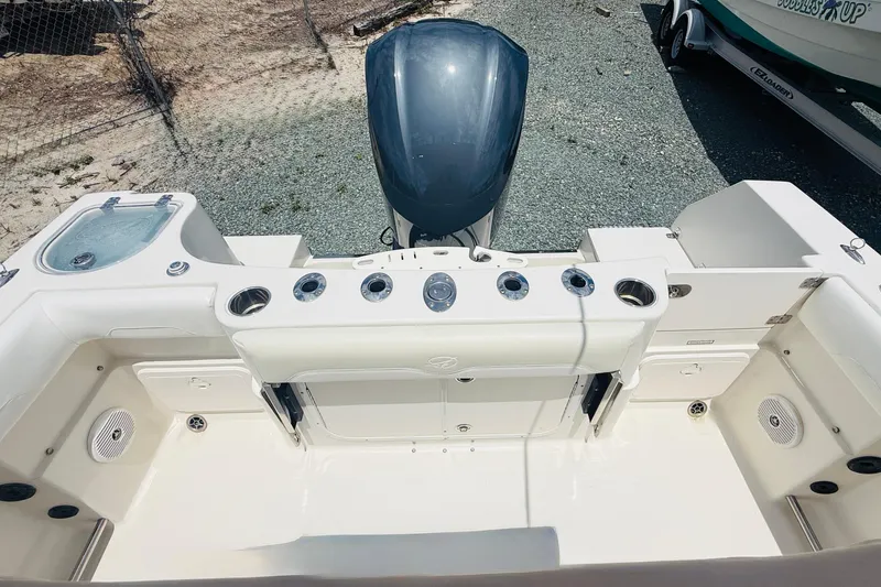 Slide: The Image of 2015 Sailfish 240 CC boat interior with fishing rod holders and storage compartments. - 13