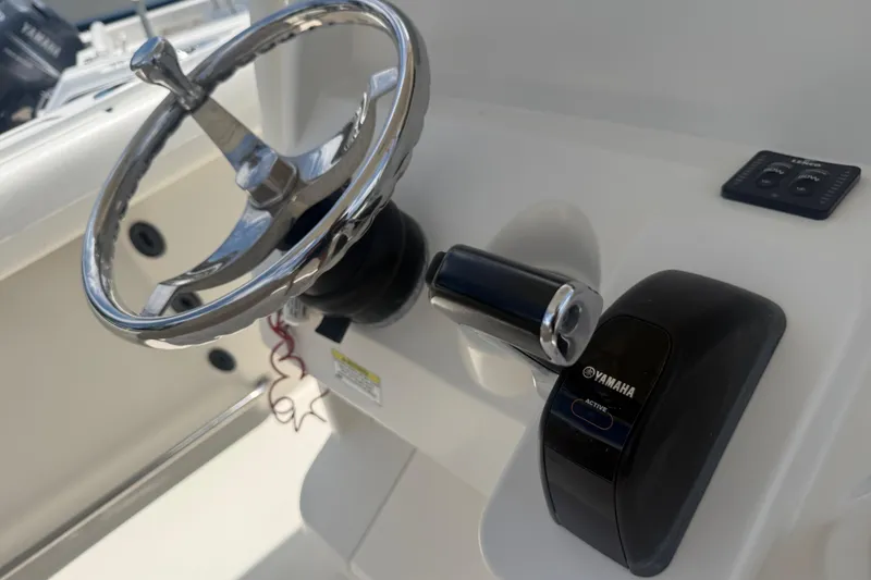 Slide: The Image of Steering wheel and throttle of 2015 Sailfish 240 CC boat with Yamaha controls. - 16