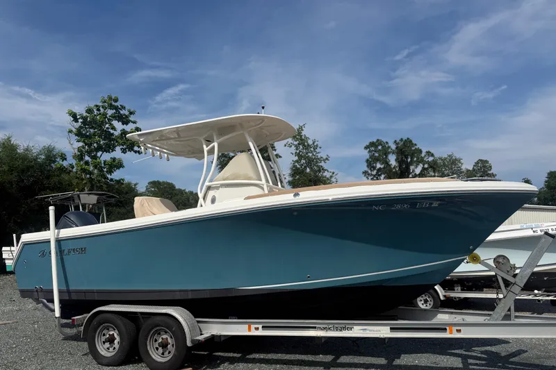 Slide: The Image of 2015 Sailfish 240 CC boat on trailer under clear blue sky. - 2