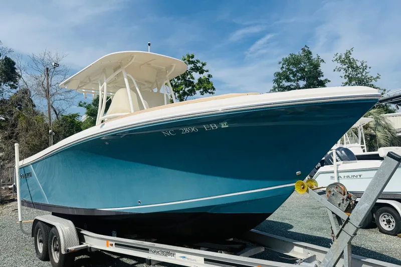 Slide: The Image of 2015 Sailfish 240 CC boat on trailer, blue hull, parked outdoors. - 3