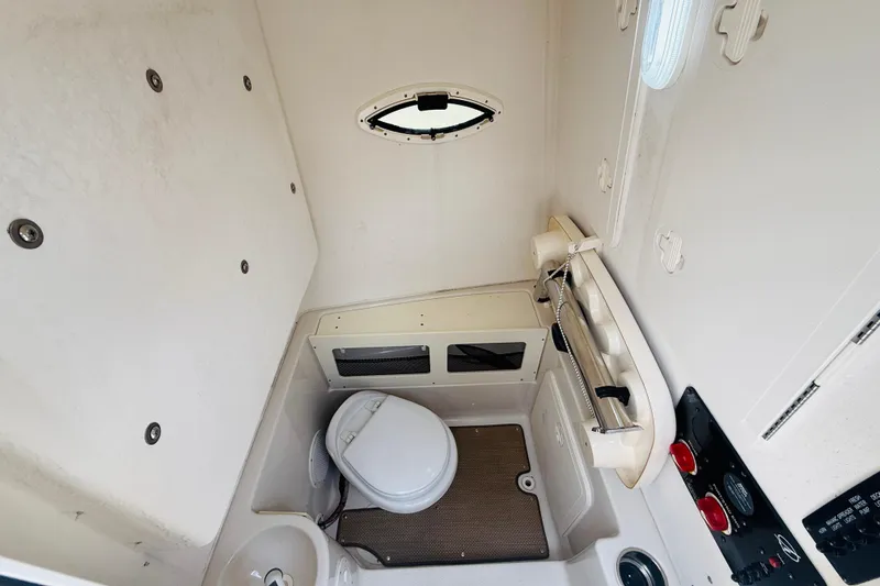 Slide: The Image of 2015 Sailfish 240 CC boat interior with compact marine toilet and sink. - 8