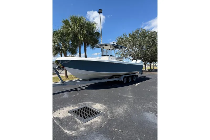 Slide: The Image of 2005 Bluewater 2850 CC boat on trailer, parked under clear blue sky. - 5